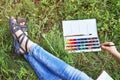 Creative girl painting sitting on grass in summer