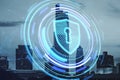 Creative glowing blue shield hologram on blurry city backdrop. Secure, safety, database and web protection concept. Double