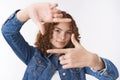 Creative good-looking redhead female picturing shot projecting image make frames using fingers look through it arrenging