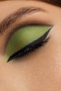 Creative green eye makeup with arrow. Beautiful macro shot of female eye make-up. Blue eye. Creative make-up. Perfect shape make-u Royalty Free Stock Photo