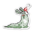 A creative gross distressed sticker cartoon of a slug wearing santa hat