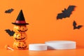 Creative Halloween composition with paper bats, podium and orange background. Modern Halloween aesthetic