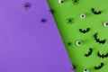 Creative Halloween horror concept with bats, eyeballs and spiders on purple and green background Royalty Free Stock Photo