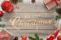 Creative hand carved Merry Christmas text in a wooden surface. Surrounded with Christmas decorations Royalty Free Stock Photo