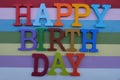 Happy Birthday composed with multicolored wooden letters over multicolored wooden board