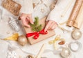 Creative hobby. Woman`s hands wrap christmas holiday handmade present in craft paper with twine ribbon. Making bow at Royalty Free Stock Photo