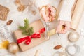 Creative hobby. Woman`s hands wrap christmas holiday handmade present in craft paper with twine ribbon. Making bow at Royalty Free Stock Photo