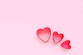 Creative holiday concept of love. Three cookie cutters in a shape of heart on a pink background. Valentine's Day concept