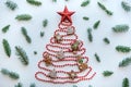 A Christmas tree made of beads decorated with traditional gingerbread and a star on top. Royalty Free Stock Photo