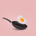 Creative idea with a frying pan and a flying fried egg in heart shape on a bright pink background Royalty Free Stock Photo