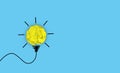 Creative idea and innovation concept. crumpled paper ball yellow color with light bulb symbol on blue background. Conceptual Royalty Free Stock Photo