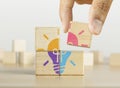 Creative idea, innovative idea, brainstorming or enlightenment concept. Hand putting the last piece of wooden blocks with the Royalty Free Stock Photo