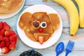 Creative idea for kids breakfast. Dog shaped pancakes with berries on blue wooden table, top view. Healthy food for Royalty Free Stock Photo