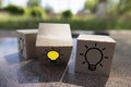 Creative idea, New idea, innovation and solution concept. wooden cubes with the yellow light bulb symbol on table, blue background Royalty Free Stock Photo