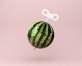 Creative idea wind up key with watermelon on pastel pink background. minimal business ideas, food and fruit concept