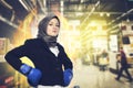 Successful and aggressive young muslimah businesswomen with boxing glove over abstract double exposure background Royalty Free Stock Photo