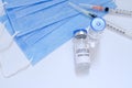 Creative ideas of vaccination concept. Top view of syringe with medical masks and vaccine vial glass bottles for vaccination. Royalty Free Stock Photo