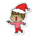 laughing sticker cartoon of a man pointing wearing santa hat