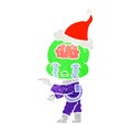 retro cartoon of a big brain alien crying and pointing wearing santa hat Royalty Free Stock Photo