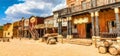 Creative illustration in vintage watercolor design - Wild West old village, rural buildings with blue sky