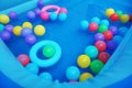 A creative image of a bunch of colorful plastic balls floating in a children\'s bath