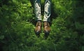 Creative image of outdoor recreation with male feet in brown shoes on a green meadow. Symbolizes a sense of grounding and being