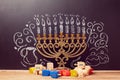 Creative Jewish holiday Hanukkah background with menorah and spinning tops over chalkboard Royalty Free Stock Photo
