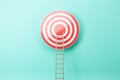 Creative ladder leading to bulls eye target on blue wall background. Targeting, career and aim concept.