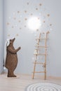Creative lamp in the children`s room. Drawn bear holding a rope with a lamp on the wall
