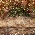 Creative layout frame made of Christmas fir branches, pine cones and gold decoration on wooden background. Royalty Free Stock Photo