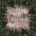 Creative layout frame made of Christmas fir branches with snowflakes on wooden background. Royalty Free Stock Photo