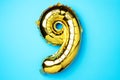 Creative layout. Golden foil balloon number and digit nine 9. Birthday greeting card. Anniversary concept. Top view