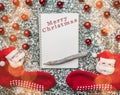 Creative layout made of Christmas baubles, stockings and spiral notebook with pencil