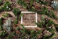 Creative layout made of Christmas fir branches with frame of paper card note, pine cones and snowflakes on wooden background Royalty Free Stock Photo