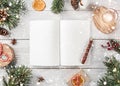 Creative layout made of Christmas tree branches with holiday book, pencil, pine cones, gifts on white background. Xmas