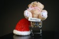 Red Christmas hat, coins in miniature of trolley and cute teddy bear toy isolated on black dark background Royalty Free Stock Photo