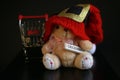 Red Christmas hat, coins in miniature of trolley and cute teddy bear toy isolated on black dark background Royalty Free Stock Photo