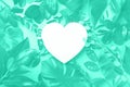 Creative layout made of tropical leaves, heart shaped paper in mint color. Trendy green and turquoise color. Flat lay. Top view.