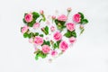 Creative layout with pink tea rose flowers, petals and leaves in shape of heart on white background isolated. Summer, spring love Royalty Free Stock Photo