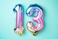 Creative layout. Rainbow foil balloon number, digit thirteen. Birthday greeting card with inscription 13. Anniversary