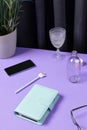 Creative layout with stationery, coffee cup and smartphote on purple table