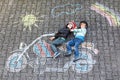 Creative leisure for children: two little funny friends in helmet having fun with motorcycle picture drawing with