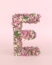 Creative letter E concept made of frash Spring wedding flowers. Flower font concept on pastel pink background