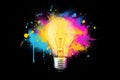 Creative light bulb explosion with splashes of yellow, blue and pink paint on a black background. Think differently, creative idea Royalty Free Stock Photo