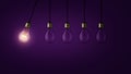 Creative light bulb lights up other extinguished light bulbs on a dark purple background, concept. Leadership, creative idea. Royalty Free Stock Photo