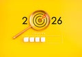 Creative loading bar concept with 2026 target under magnifying glass on yellow background. Goal setting, planning, and success in Royalty Free Stock Photo