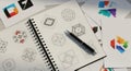 Creative logo design process sketchbook open with pen and various brand concepts displayed Royalty Free Stock Photo