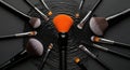 Creative makeup brushes arranged around a bright orange lightbulb idea concept Royalty Free Stock Photo