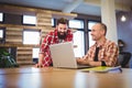 Creative male coworkers discussing over laptop