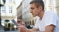 Creative man sitting on sidewalk and using tablet computer Royalty Free Stock Photo